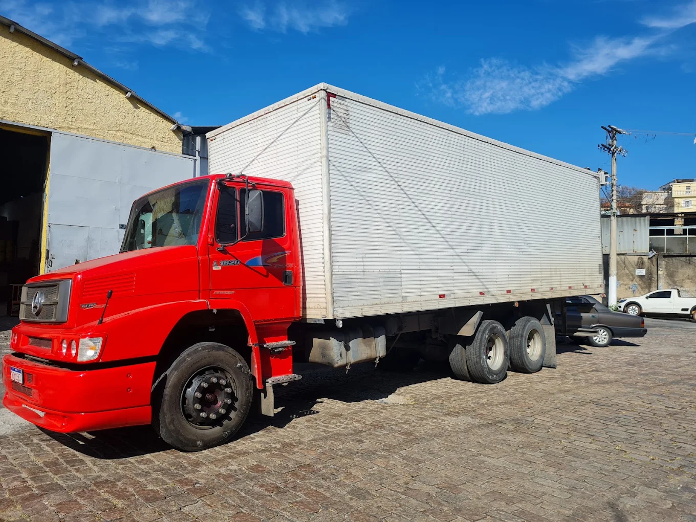 Caminhão baú vermelho da PJT Transportes